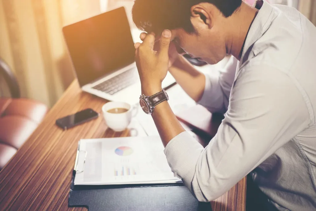 A young man being stressed while working on the laptop.  