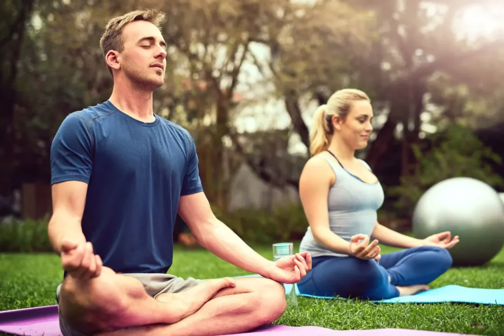 A couple is doing yoga. 