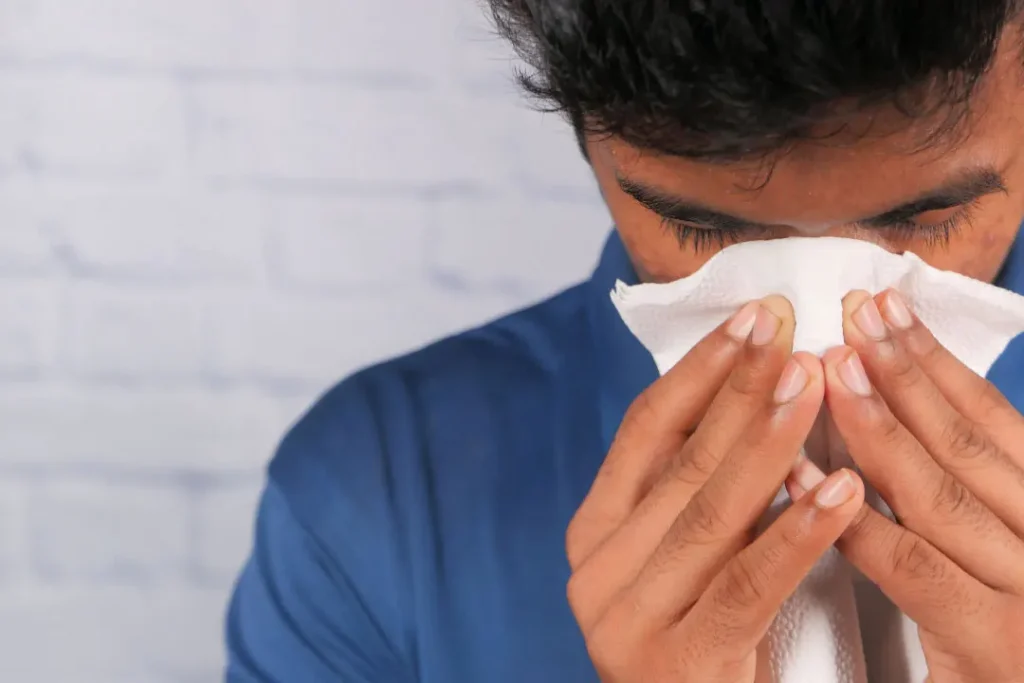 Boy wiping his nose.