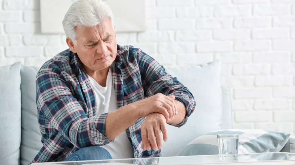 Old man having pain in his hand. 