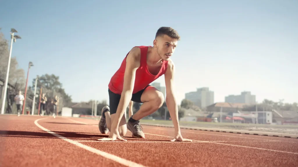 Young man is ready to run on the ground. 